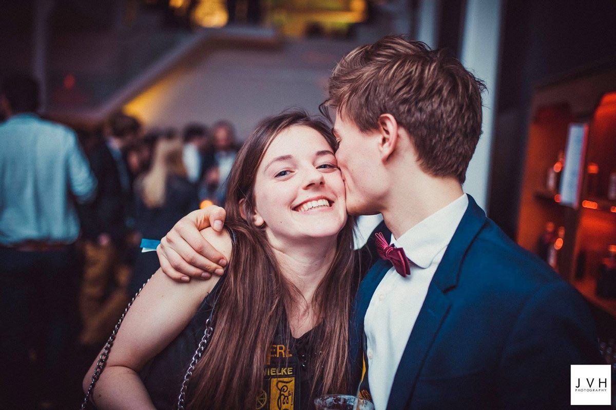 Emiel geeft Valerie een kus op de wang op een druk feest