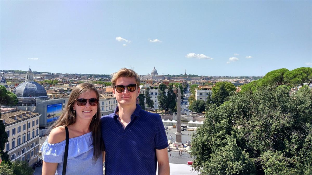 Valerie en Emiel met zonnebrillen boven de Piazza del Popolo in Rome, met de koepel van de Sint-Pietersbasiliek in de verte